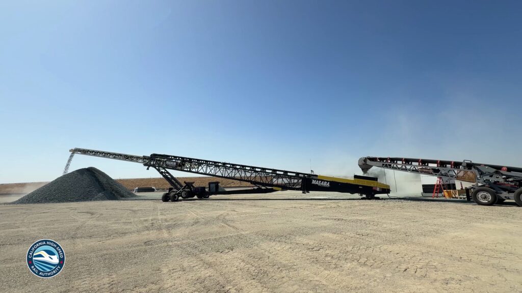 Conveyor stacker dropping crushed ballast rock into a pile at a California High-Speed Rail construction site
